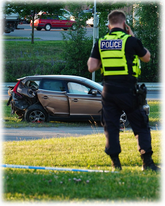 A police officer standing in front of an accident scene.