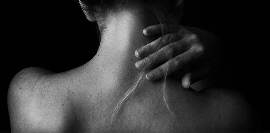 A person with their hands on the back of their neck.
